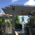 A sleek aluminum pergola structure providing shade and architectural interest in a backyard.