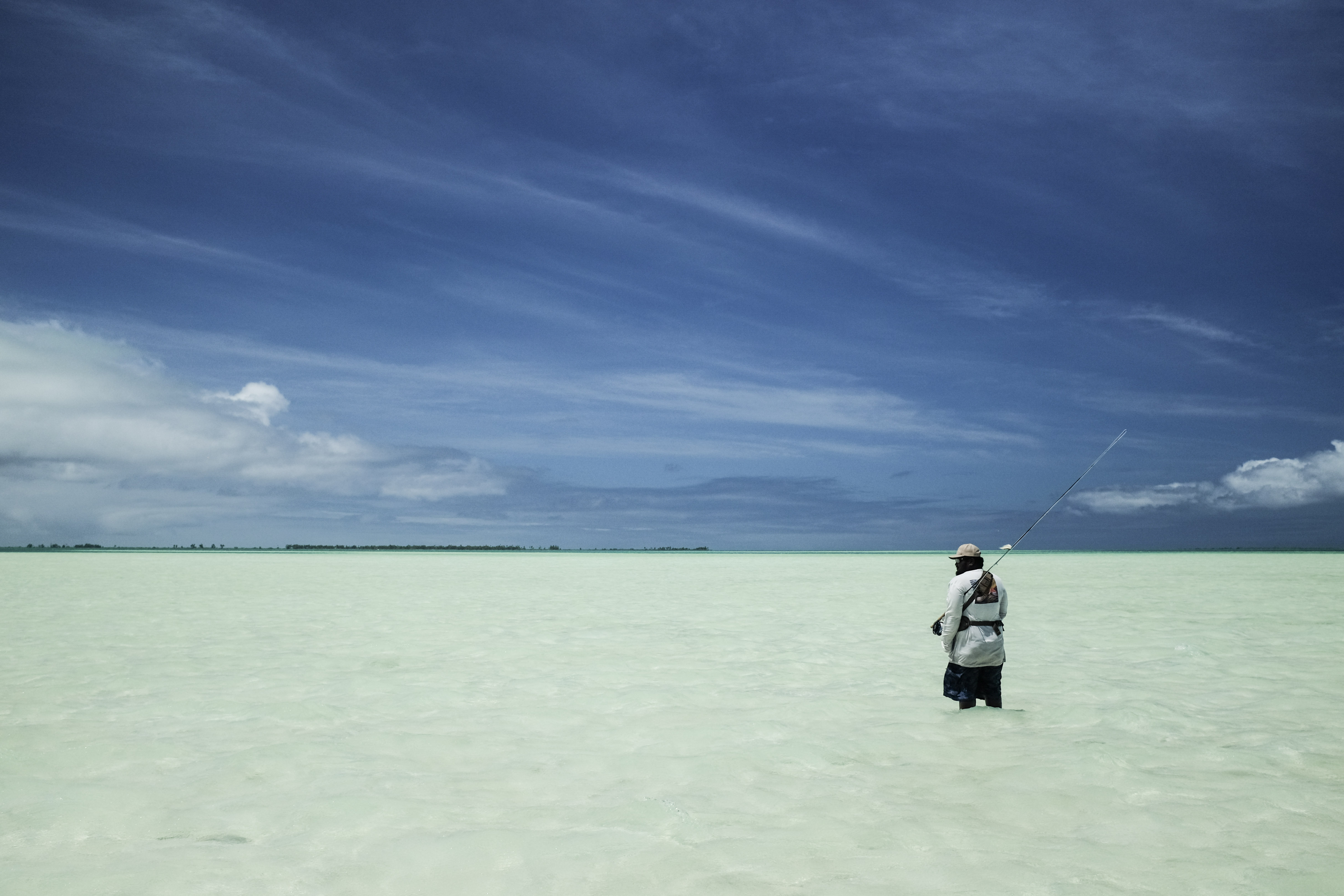 Angler holds a large Permit next to friends while Fly fishing in Mexico.