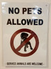 Compliance sign NO PETS ALLOWED SERVICE ANIMALS ARE WELCOME - WHITE BACKGROUND
