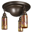  A traditional, Victorian or transitional Craftsman style ceiling light fixture with an oil rubbed bronze finish and three hanging lights. The lights have cylindrical blown glass shades with a red feather design.