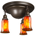  A traditional, Victorian or transitional Craftsman style ceiling light fixture with an oil rubbed bronze finish and three hanging lanterns. The lanterns have illuminated, trumpet shaped blown glass shades with a cherry blossom design.