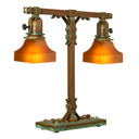  A stout and burly Arts & Crafts or Craftsman table lamp with an aged patina finish and tapered, orange glass shades.