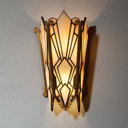  Front view of an illuminated Art Deco wall sconce featuring a double-paneled diamond stained glass shade with iridescent reflections and bronze trim.