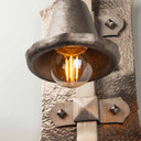 Illuminated Edison-style bulb in hand-forged pewter lantern shade showcasing warm ambient lighting and traditional metalwork.