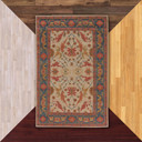  A decorative Victorian or Tudor area rug features a symmetrical design with stylized floral motifs in warm tones of red, gold, and blue on a light background. A bold navy border with geometric and floral accents frames the intricate central pattern, giving it a classic, traditional look.