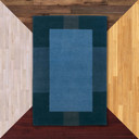  A Mid-Cenutry Modern, rectangular wool rug featuring a minimalist color-blocked design in shades of blue against floor color samples. 