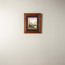  A print of a painting commemorating the anniversaries of Route 66 and Colorado Boulevard in Pasadena, California. It is in an oak frame.