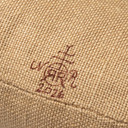  Close-up of warm brown Roycrofters maker's monogram mark and date on natural linen fabric.
