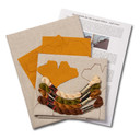  Overhead view of a embroidery kit for a gingko pillow design, showing folded natural linen stamped with a gingko leaf pattern alongside arranged embroidery thread skeins in beige, olive green, rust and brown with instructions.