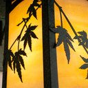  Detail of a rustic, artistic wall mounted light fixture with Japanese Maple artwork, an aged verdigris finish and golden glass.