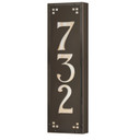  A solid brass, vertically oriented illuminated house number plaque with a three number address, a bronze finish, warm glass and corner glass accents.
