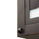  Detail corner rivets of a horizontal brass blacker house mailbox with an bronze finish and warm toned glass with red and green accents.