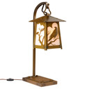  A beefy, rustic table lamp on a hooked arm with Gothic literature raven silhouettes in trees, an aged brass finish and off white glass.