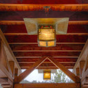 An pair of reproduction porte-cochere driveway lanterns from the Blacker House in Pasadena, California. The lanterns have an abstract vine design, aged patina finish and iridescent glass.