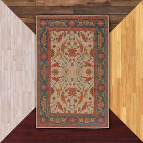  A decorative Victorian or Tudor area rug features a symmetrical design with stylized floral motifs in warm tones of red, gold, and blue on a light background. A bold navy border with geometric and floral accents frames the intricate central pattern, giving it a classic, traditional look.