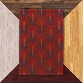  A checkerboard Scandinavian style Mid-Century wool rug in a deep burgundy and red palette. It's on a background of floor color samples.