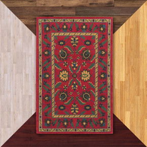  A rectangular oriental red rug with a complex floral pattern. The center is filled with large, symmetrical flower and leaf shapes in green, yellow, and blue. It is on a background of floor color samples. 