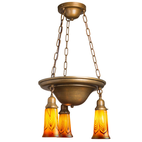  A traditional, Victorian or transitional Craftsman style chandelier with an aged finish and three lanterns. It features illuminated, fluted blown glass shades with a red feather design.