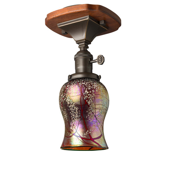  A ceiling mounted Arts & Crafts light fixture with a wood mounting plate featuring rounded corners and brass accents. The lantern has a turn key socket, an oil rubbed bronze finish and a tulip shaped cherry blossom blown glass shade.