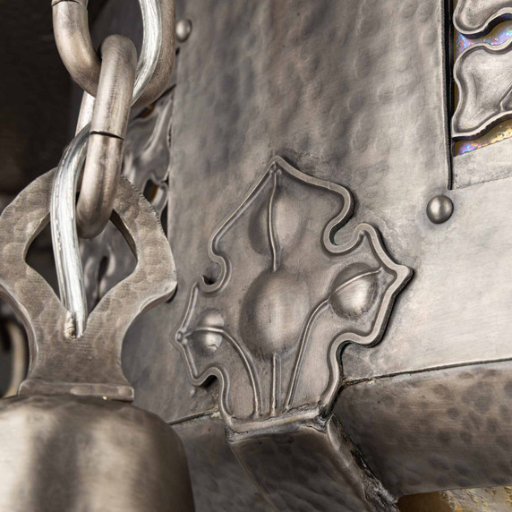  Detailed view of ornate pewter scrollwork and decorative panels with iridescent glass accents on ceiling fixture. Tudor Revival lighting showcasing hand-forged metalwork and period-appropriate design elements.