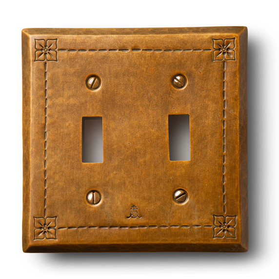  A hammered brass, dual toggle switch plate cover with a warm patina finish.