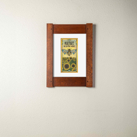  An archival print of a bee with sunflowers. It has a white mat and mortise and tenon oak frame.