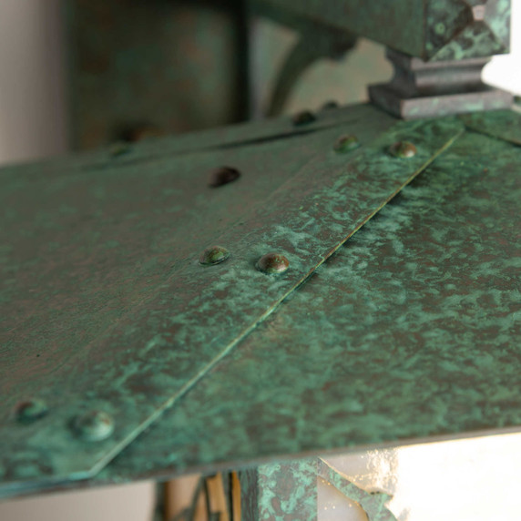  Detail of a rustic, artistic wall mounted light fixture with Japanese Maple artwork, an aged verdigris finish and golden glass.