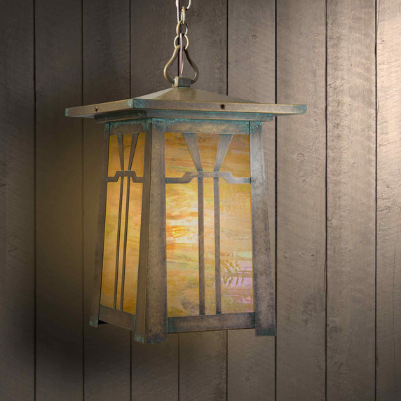  An Arts & Crafts chain mounted pendant light fixture with an aged patina brass finish, iridescent glass and a Gamble House design.
