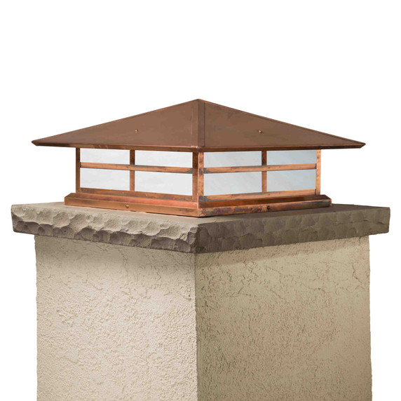  A Prairie Style column mounted pier light fixture with a window pattern, raw copper finish and white glass.