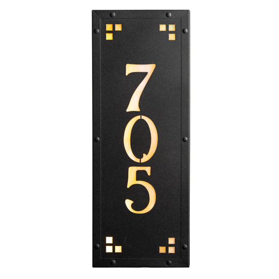  A solid brass, vertically oriented illuminated house number plaque with a three number address, a satin black finish, warm-toned glass and corner glass accents.