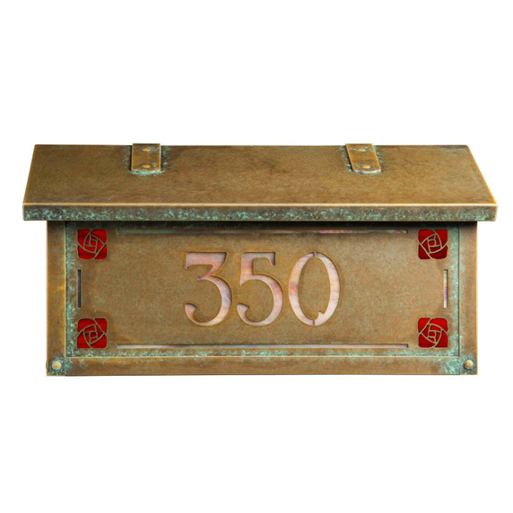  Front view of a Craftsman style mailbox featuring the Hunter Rose (sometimes called the Mackintosh Rose) as corner design accents. The mailbox has an aged patina finish and house address numbers backed by iridescent glass.