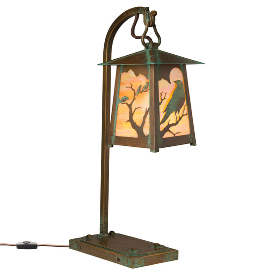  A beefy, rustic table lamp on a hooked arm with Gothic literature raven silhouettes in trees, an aged patina finish and iridescent glass.
