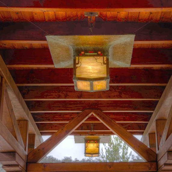  An pair of reproduction porte-cochere driveway lanterns from the Blacker House in Pasadena, California. The lanterns have an abstract vine design, aged patina finish and iridescent glass.