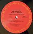 Bob Dylan ‎– Pat Garrett & Billy The Kid - Original Soundtrack Recording
Label:
Columbia ‎– 19075907251
Format:
Vinyl, LP, Album, Reissue
Country:
US
Released:
05 Apr 2019
Genre:
Rock, Stage & Screen
Style:
Folk Rock, Country Rock, Soundtrack
Pat Garrett & Billy The Kid - Original Soundtrack Recording (Vinyl, LP, Album, Reissue) for sale
More Images

Tracklist
Position	Artists	Title/Credits	Duration
A1	–Booker T*, Bruce Langhorn*, Bob Dylan	Main Title Theme (Billy)
Tambourine – Russ Kunkel
6:00
A2	–Roger McGuinn, Bruce Langhorn*, Bob Dylan	Cantina Theme (Workin' For The Law)
Bongos – Russ Kunkel
2:50
A3	–Booker T*, Bruce Langhorn*, Bob Dylan	Billy 1	3:51
A4	–Carol Hunter & Bob Dylan	Bunkhouse Theme	2:10
A5	–Booker T*, Bruce Langhorn*, Bob Dylan	River Theme
Voice [Voices] – Byron Berline, Donna Weiss, Priscilla Jones
1:32
B1	–Bob Dylan	Turkey Chase
Acoustic Guitar – Bruce Langhorn*
Banjo – Jolly Roger (5)
Bass – Booker T*
Fiddle – Byron Berline
Rhythm Guitar – Bob Dylan
3:29
B2	–Terry Paul, Roger McGuinn, Jim Keltner, Bob Dylan	Knockin' On Heaven's Door
Harmonium – Carl Fortina
Voice [Voices] – Brenda Patterson, Carol*, Donna*
2:28
B3	–Bob Dylan	Final Theme
Bass – Terry Paul
Cello [Cellos] – Fred Katz, Ted Michel
Drums – Jim Keltner
Guitar [Guitars] – Bob Dylan, Carol Hunter, Roger McGuinn
Harmonium – Carl Fortina
Recorder, Flute – Gary Foster
Voice [Voices] – Brenda*, Donna*, Terry Paul
5:18
B4	–Bob Dylan & Terry Paul	Billy 4 (Recorded In Mexico City)	4:57
B5	–Jim Keltner, Roger McGuinn, Terry Paul & Bob Dylan	Billy 7	2:01