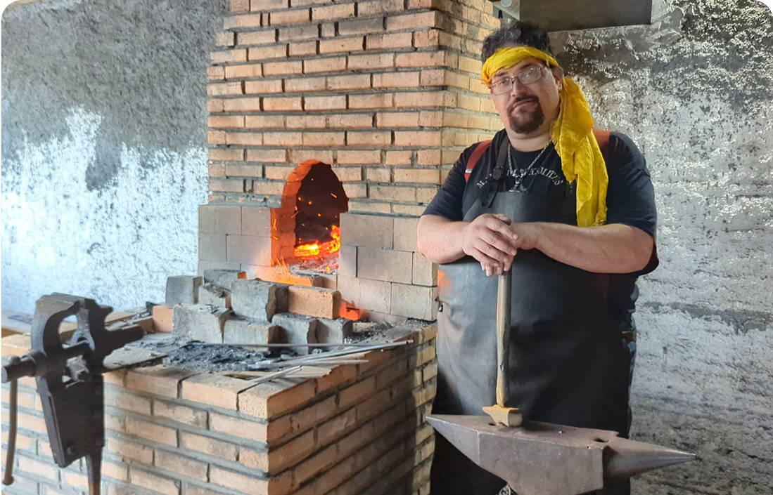 Blacksmith forging hot metal with hammer and anvil
