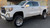 Installed suspension lift on a modern GMC white pickup truck
