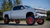 Installed suspension lift on a modern GMC truck with red rims