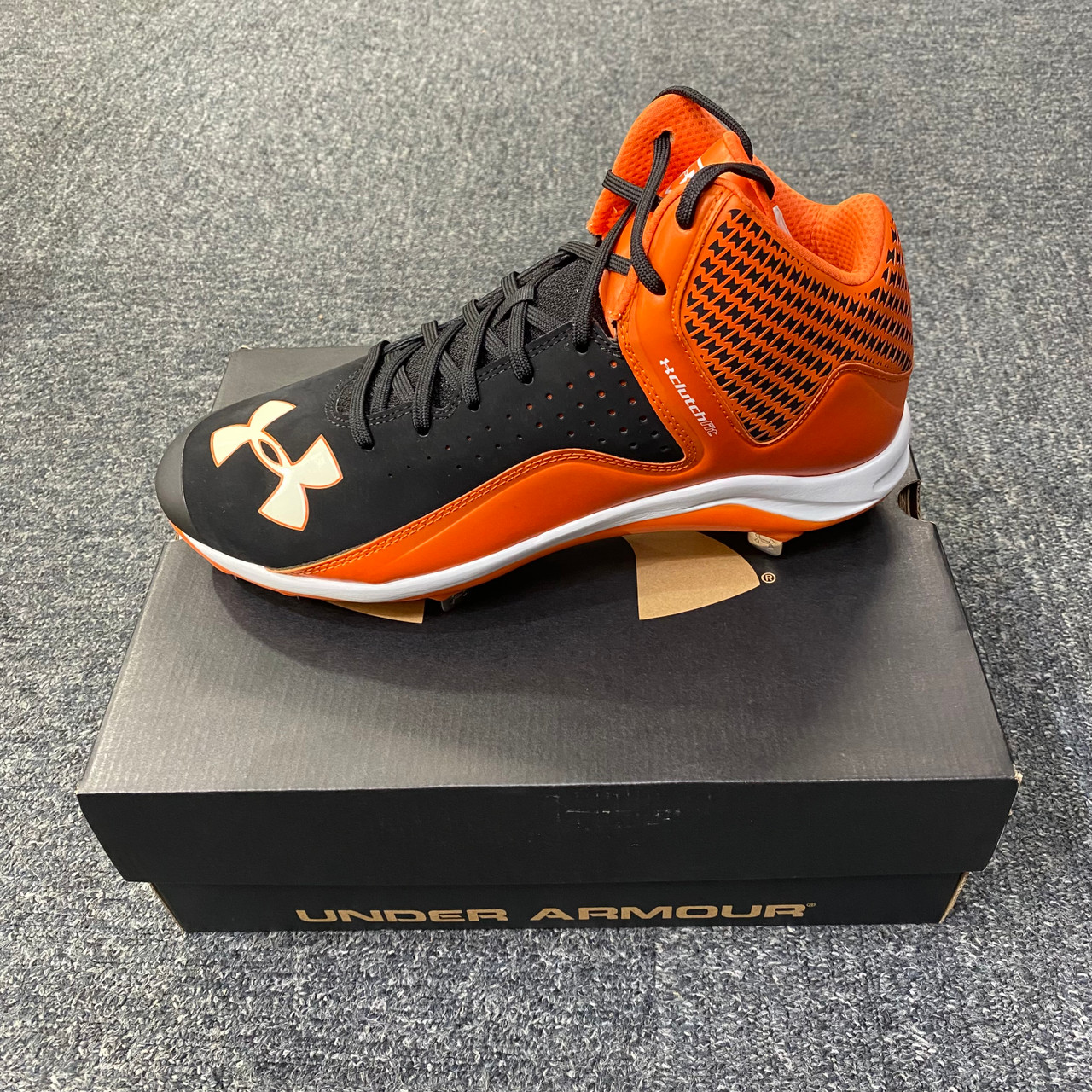 orange and black under armour baseball cleats