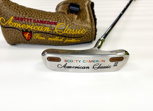 Vist Large View of Product Image Which is The Scotty Cameron American Classic series is a testament to good old-fashioned craftsmanship and design. The American Classic III Blade is a traditional design implementing high tech materials for optimal performance. The American Classic III Blade is milled out of a solid billet of soft 303 stainless steel, never before made this way, and completes the putter with two copper weight inlays in the sole enlarging the sweet spot and maximizing heel and toe balance. The American Classic III Blade has a thinned out toe and heel for a sleek, confidence-inspiring look, a re-designed neck, which flows into the head, and a single sight dot to provide a focus point. To maximize feel Scotty uses a hand wrapped leather grip imported from Australia for the perfect combination of feel and hi-tech performance. Finally, the headcover features Amerrican Classic graphics on an olive, hammered walnut textured background. The American Classic III Blade is classically elegant and made to perform!