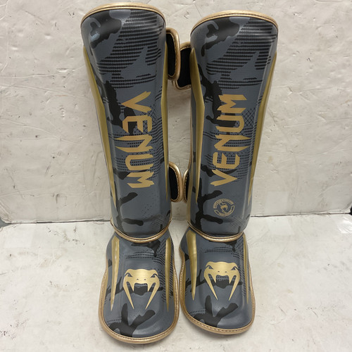 Vist Large View of Product Image Which is Used Venum ELITE SHIN GUARDS 1394-535 Martial Arts Shin Pads Black And Gold LG