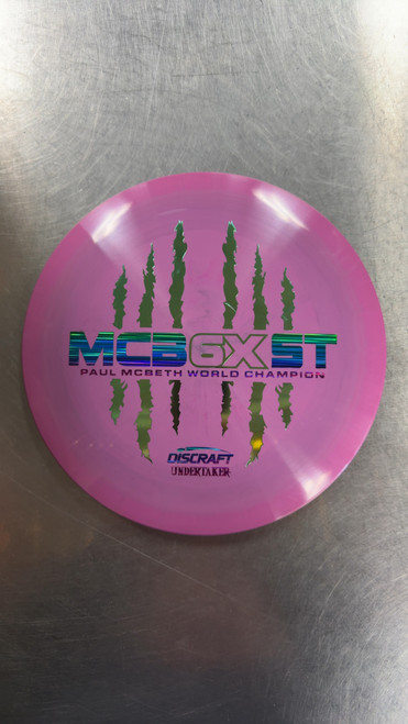 Vist Large View of Product Image Which is Used Discraft ESP MCBETH 6X CLAW UNDERTAKER Disc Golf Driver Purple