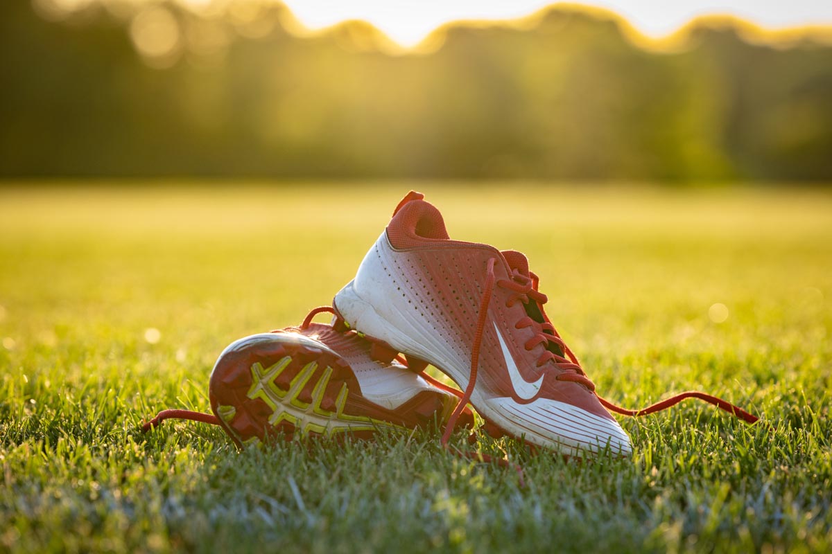 pair of red and white cleats on the grass