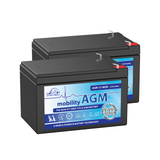 A pair of Leoch AGM-15-MOB batteries, for use with Mobility scooters. The batteries are black with a blue label on the front face. Both terminals are located on the right edge, colour coded red for positive.