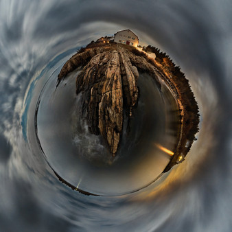 A 360-degree panoramic Spherescape capturing Lands' End on Bailey Island, Maine, at night. The image shows a glowing house atop rugged cliffs, surrounded by a darkened sea and sky, all bending into a circular form that converges into a central point