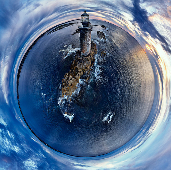 Sunrise over Rams Ledge Light in Casco Bay, Maine, captured in a 360-degree panoramic Spherescape, showcasing the lighthouse against a palette of dawn blues and sunrise golds, surrounded by the ocean’s expanse.