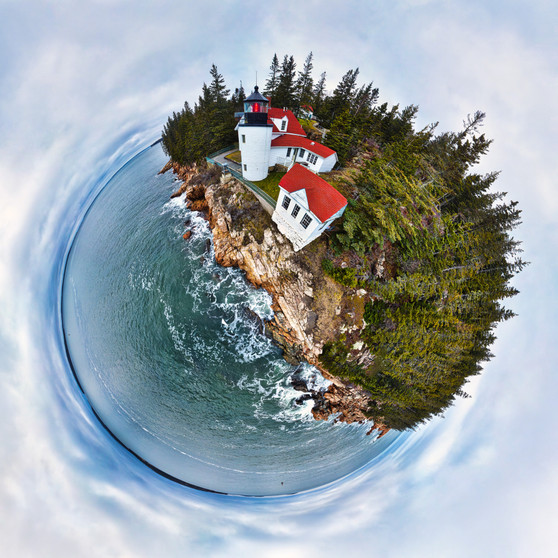 A 360-degree panoramic view of Bass Harbor Lighthouse in Acadia National Park, Maine, showcasing the vivid blues and greens of the surrounding seascape