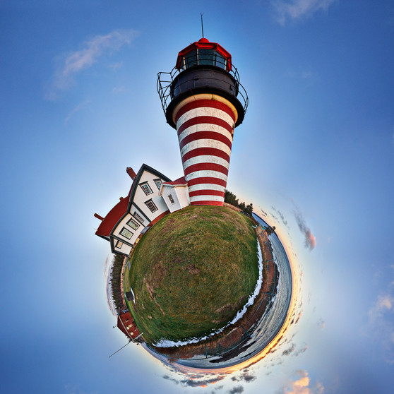 Sunrise at West Quoddy Head in Lubec, Maine, encapsulated in a 360-degree Spherescape, with the iconic red and white striped lighthouse basked in the warm sunrise hues against the cool morning sky.