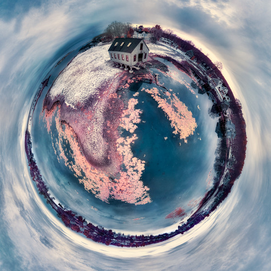 A winter color infrared panoramic Spherescape featuring the Fish House in Cape Porpoise, Maine, amidst snow-touched hues of pink and blues, warping the seascape into a spherical form.
