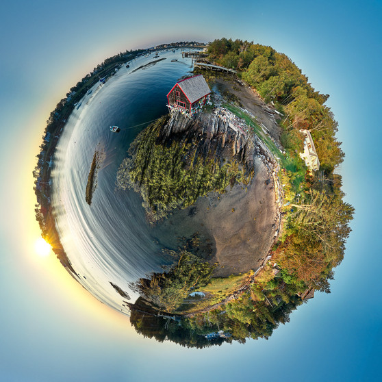 A 360-degree panoramic Spherescape featuring the Lobsterman's Shack on Bailey Island in Maine. The vivid scene encapsulates the shack surrounded by the coastline, set against the blues of the water and sky, enveloped in a circular form that centers the shack in its own world