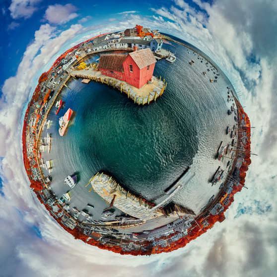 A 360-degree panoramic Spherescape presenting the iconic Motif #1 fishing shack in Rockport, Massachusetts. The image is manipulated into a circular format with vibrant, infrared-enhanced colors, making the waters appear in deep teal and the foliage in vivid magenta and crimson tones, encircled by a distorted sky with clouds and a small portion of the harbor visible in the center